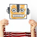 Person holding a drawing of a robot in front of their face