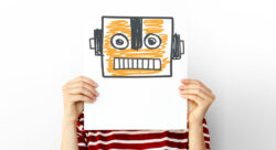 Person holding a drawing of a robot in front of their face